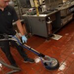 S&L Cleaning Service employee cleaning tile floor in a kitchen